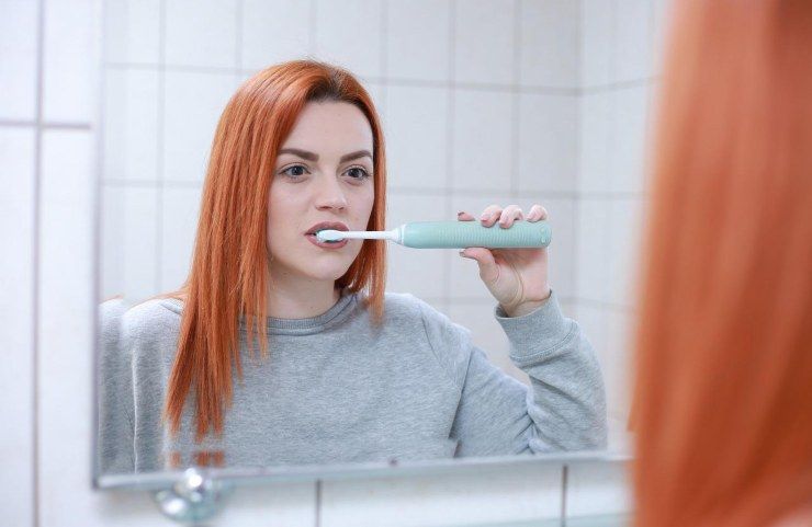 Una donna che si lava i denti